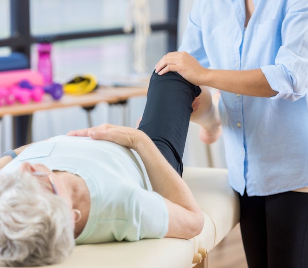 Unrecognizable chiropractor works on senior womans