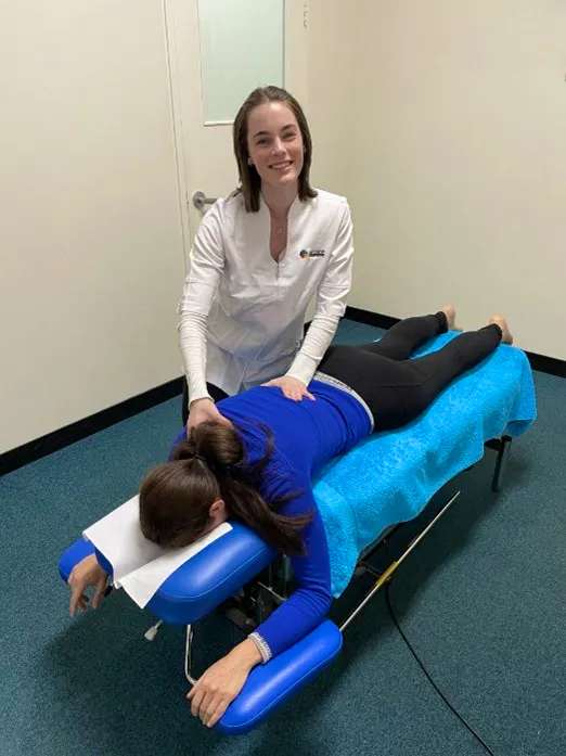 Massage therapist providing upper back soft tissue therapy for a female patient to reduce muscle tension and improve mobility.jpg