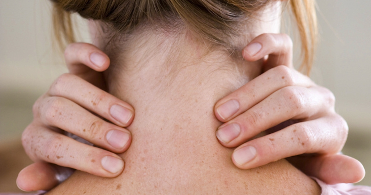 The image shows a person from behind, with hands gently holding the back of their neck, indicating a moment of relaxation or tension relief.