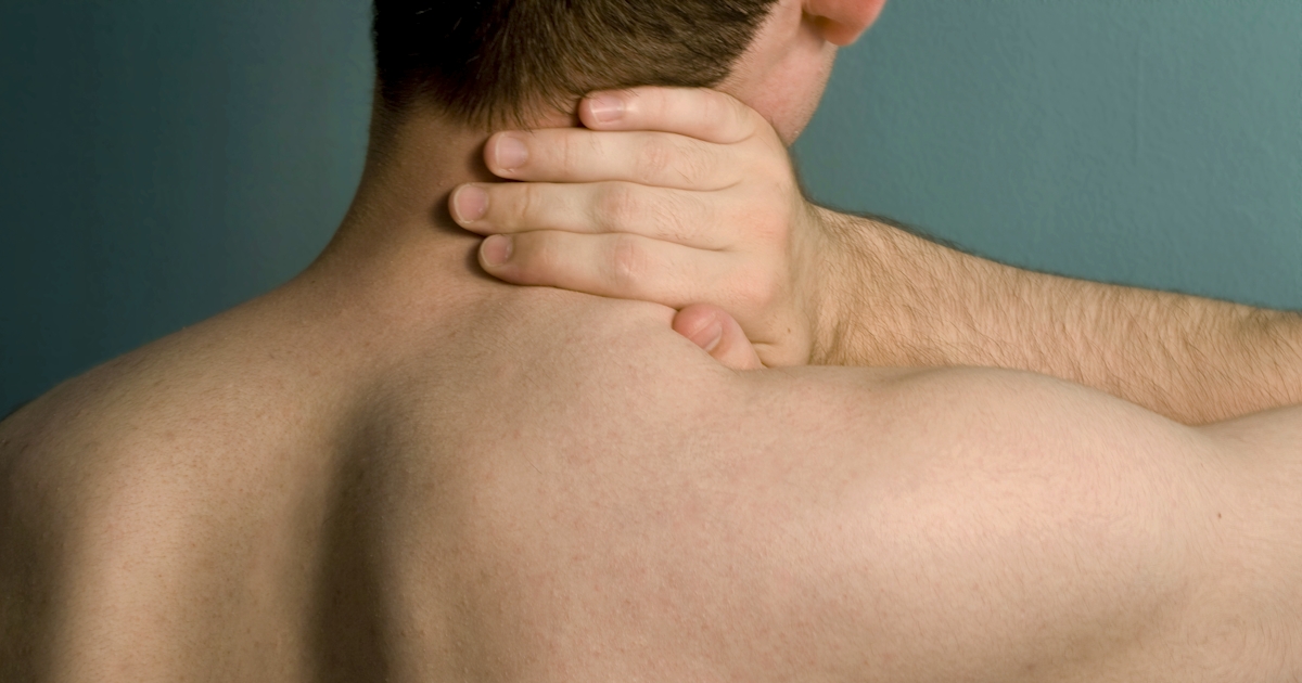 View of man from the back with hand on neck