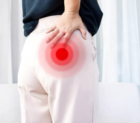 Person holding the buttock with highlighted pain associated with piriformis syndrome and sciatic nerve irritation