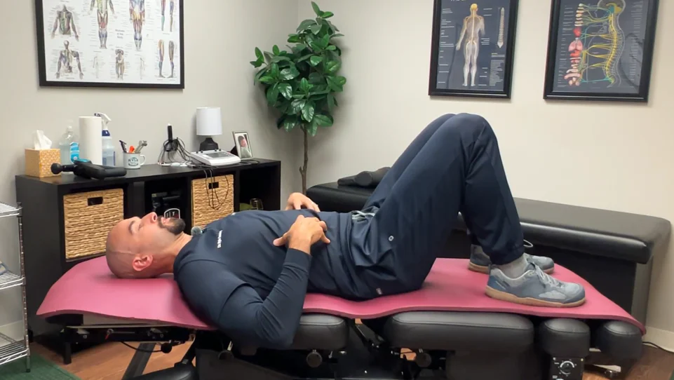 dr. dunning performing step one of the glute bridge stretch