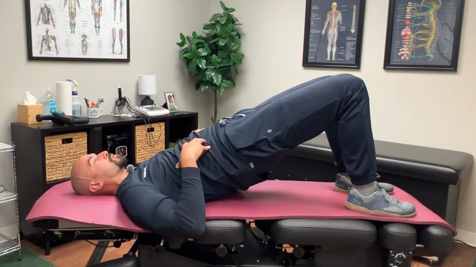 dr. dunning performing step two of the glute bridge stretch