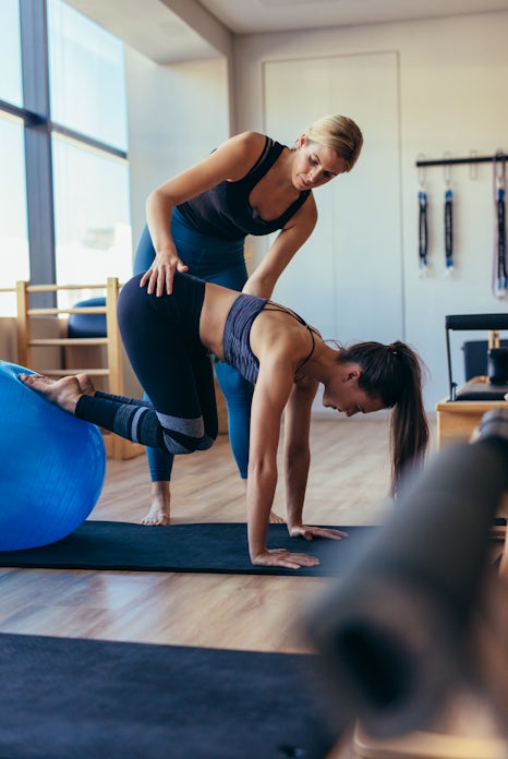 Pilates woman training with an exercise ball at gy