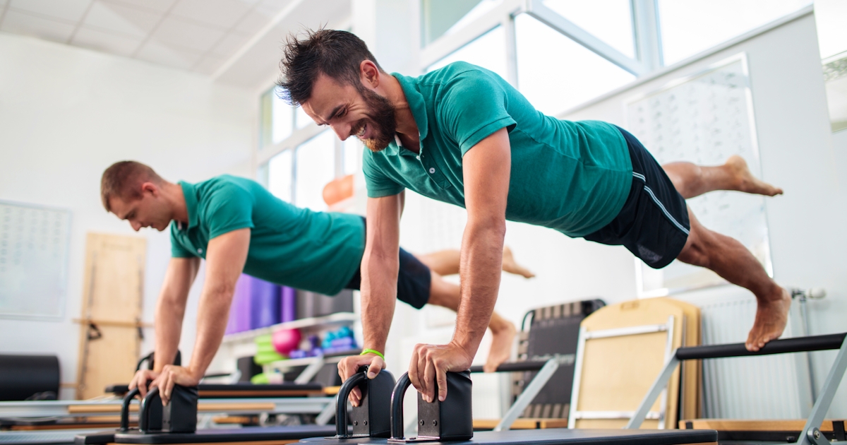 Two young men having a Pilates class at health clu
