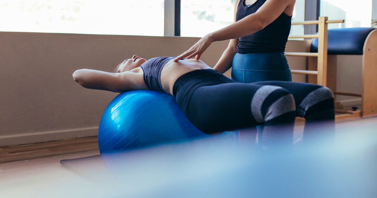 Woman training on exercise ball in a pilates train