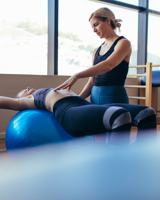 Woman training on exercise ball in a pilates train