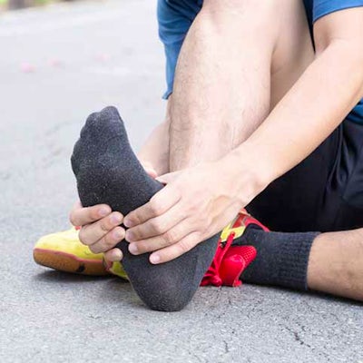 runner holding his foot in pain