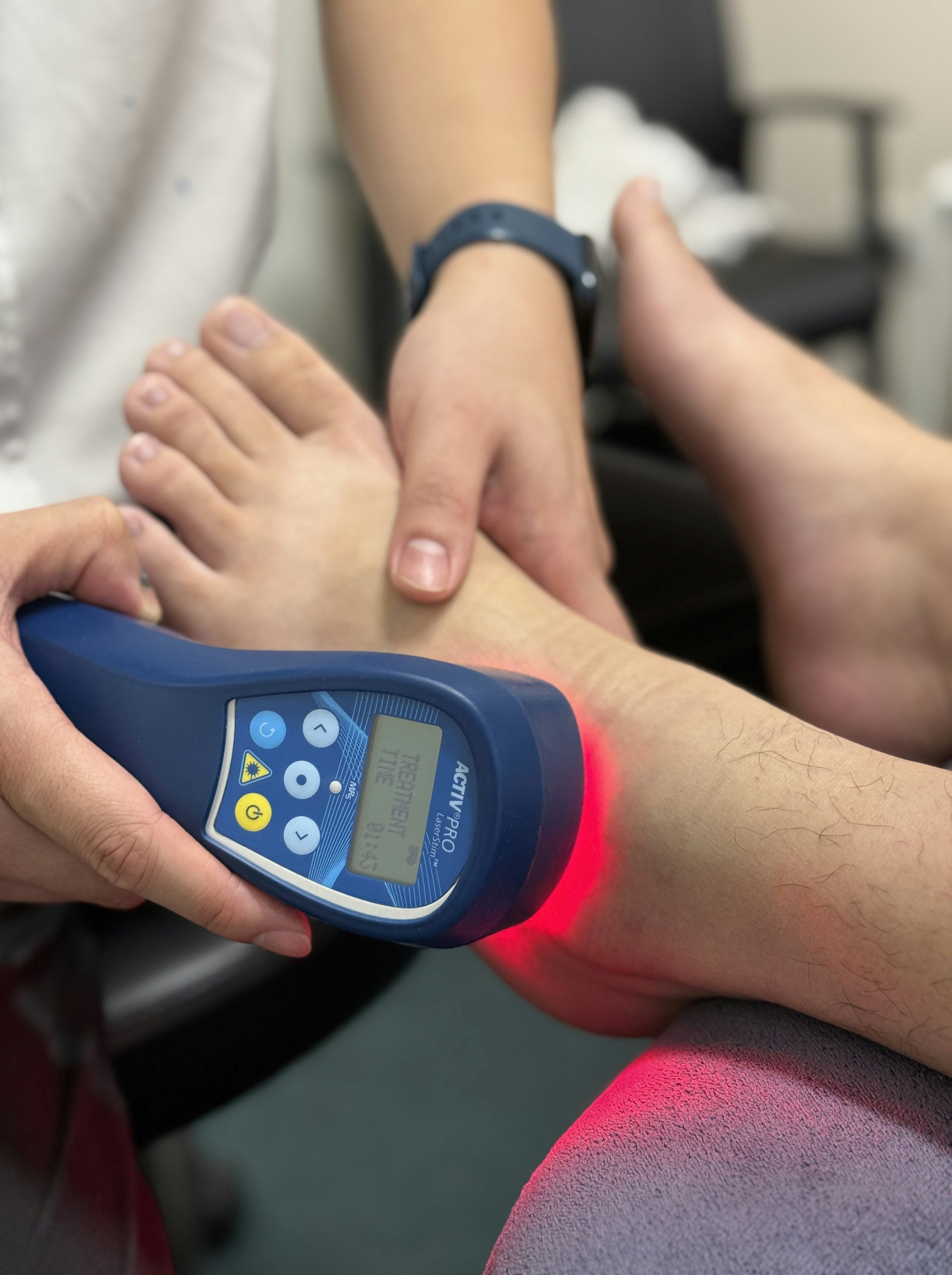 practitioner applying cold laser therapy with an mr5 active pro laserstimr device to a patients achilles tendon area