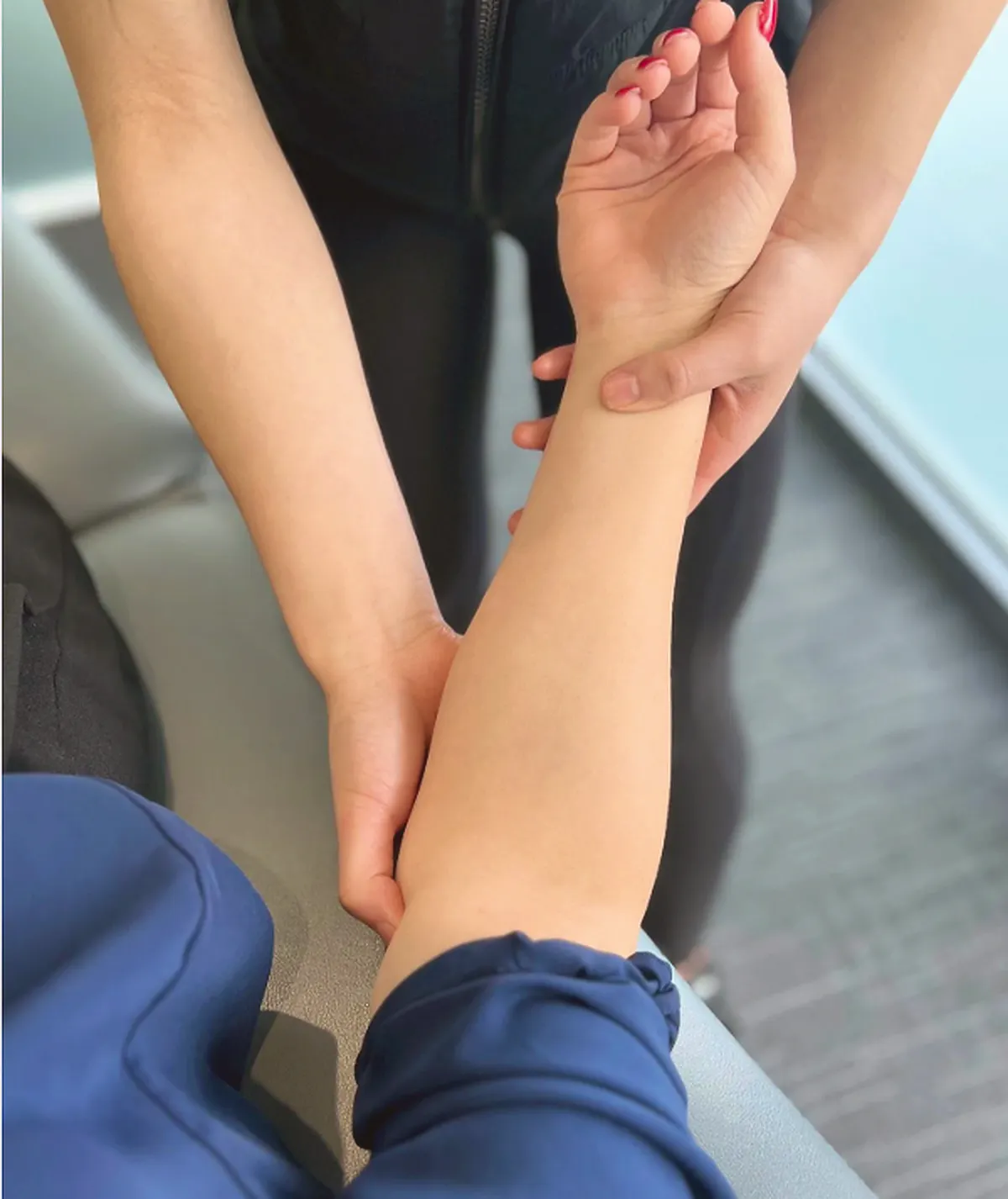 Practitioner assessing a patient's forearm and elbow for tennis elbow and tendon irritation