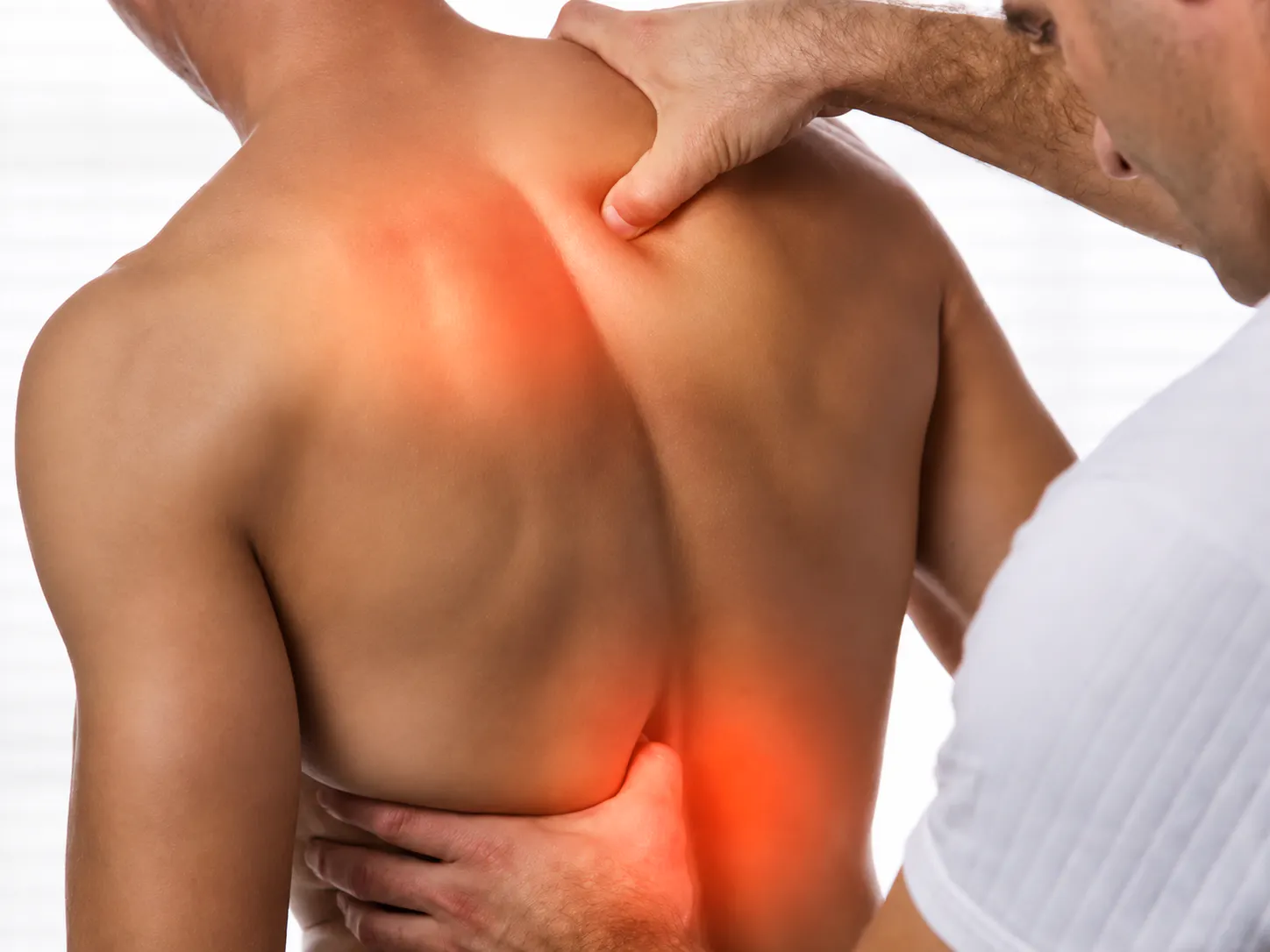 Practitioner assessing the upper back and shoulder area for acute muscle strain and pain