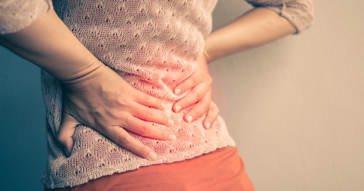 Closeup woman with hands holding her waist back in