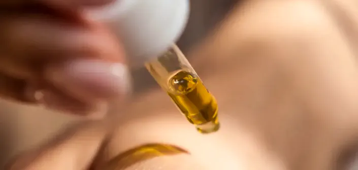 Golden castor oil being applied with a dropper
