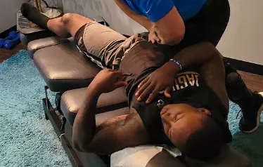Practitioner assessing and treating a patient's hip for hip bursitis