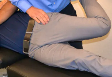 Practitioner examining a patient's hip and upper thigh during assessment