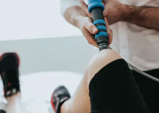 Therapeutic treatment being applied around the knee for patellar tendon pain