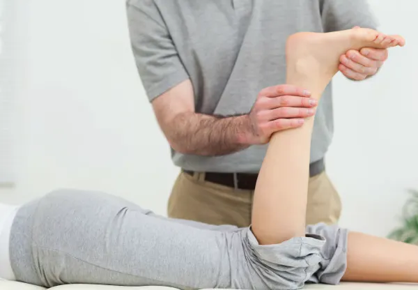 Clinician assessing and treating a patient's Achilles tendon
