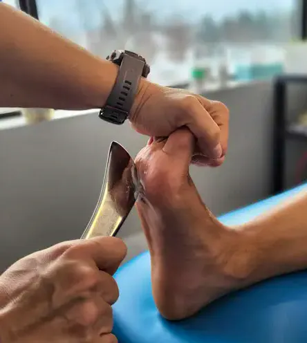 Clinician applying hands-on treatment to the forefoot