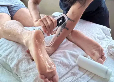 Hands-on treatment being applied around the back of the heel