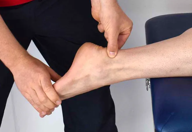 Hands-on assessment of the inside of the ankle near the tarsal tunnel