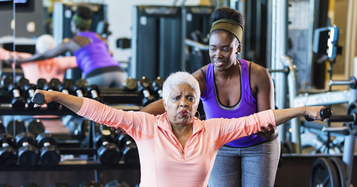 African-American fitness instructor helping senior