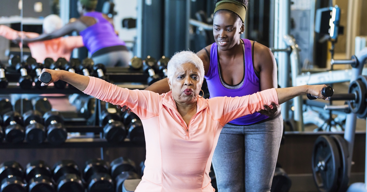 African-American fitness instructor helping senior