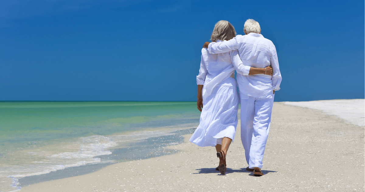 senior couple walking on beach