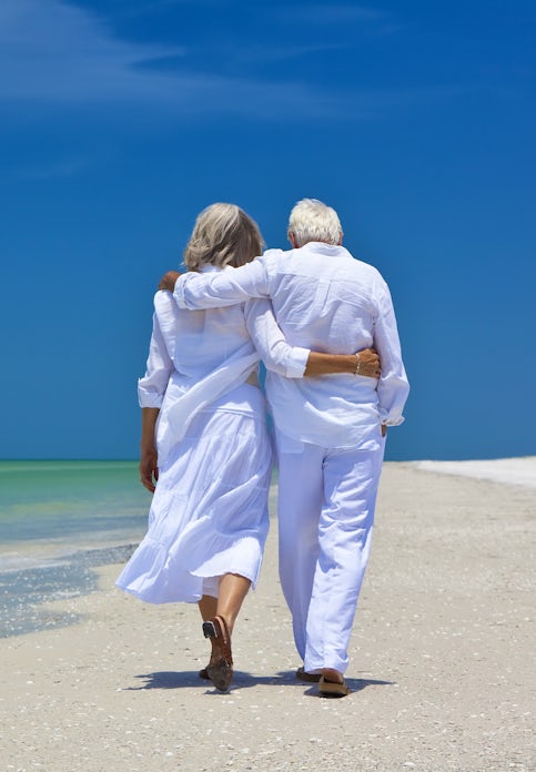senior couple walking on beach