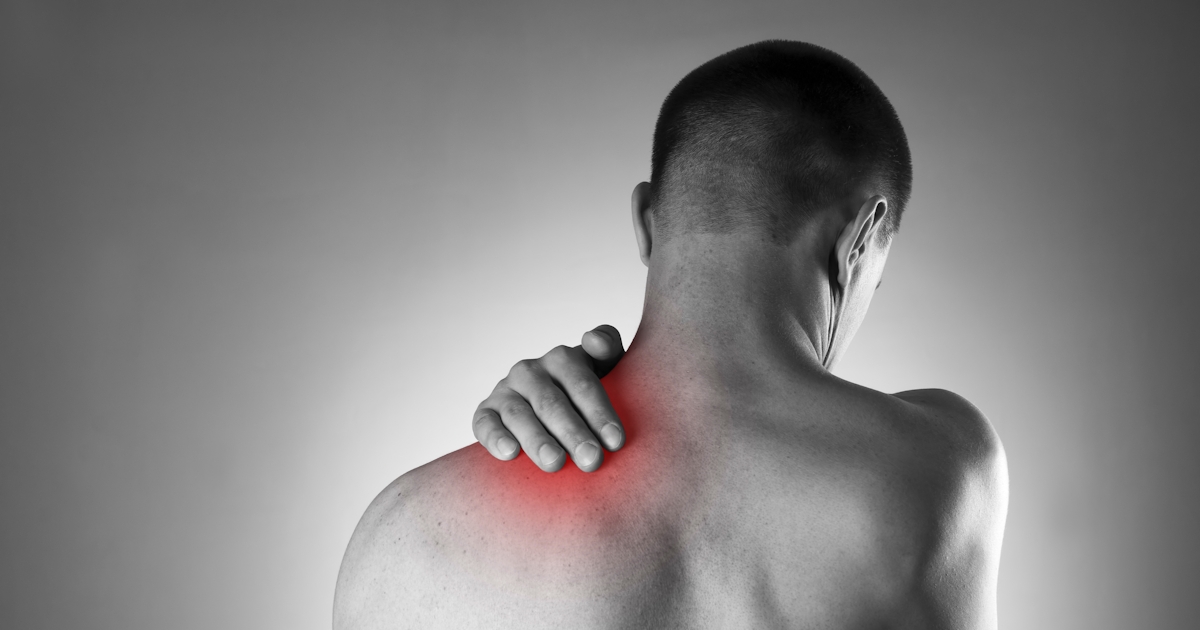 The image shows a person with their back turned, holding their shoulder, indicating discomfort or pain in the shoulder area.