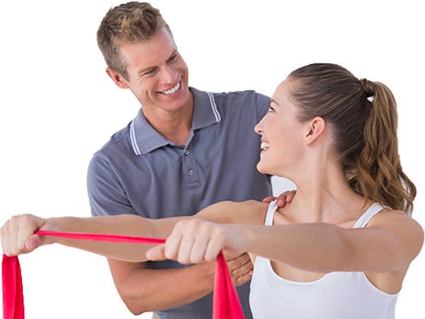 Smiling male chiropractor treating female patient during shoulder rehabilitation