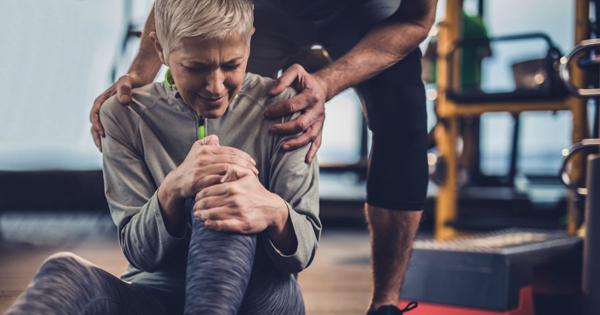 Senior female suffering with knee pain while exercising