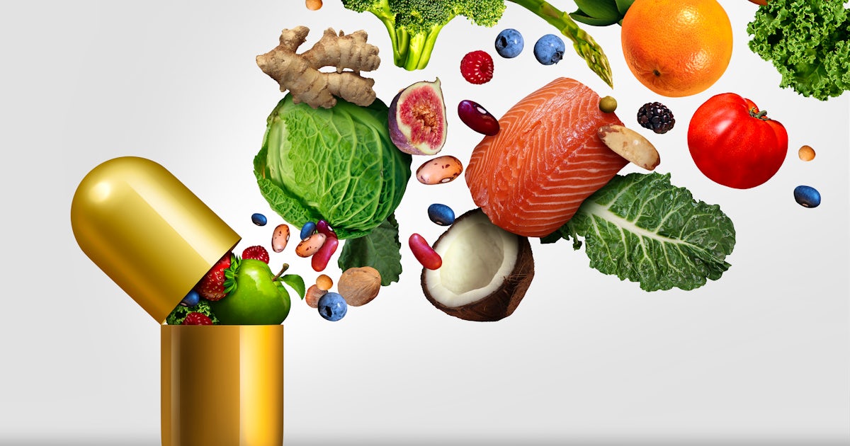 gold vitamin capsule supplement with colorful veggies spilling out