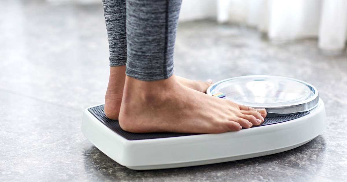 Young healthy girl on home scales