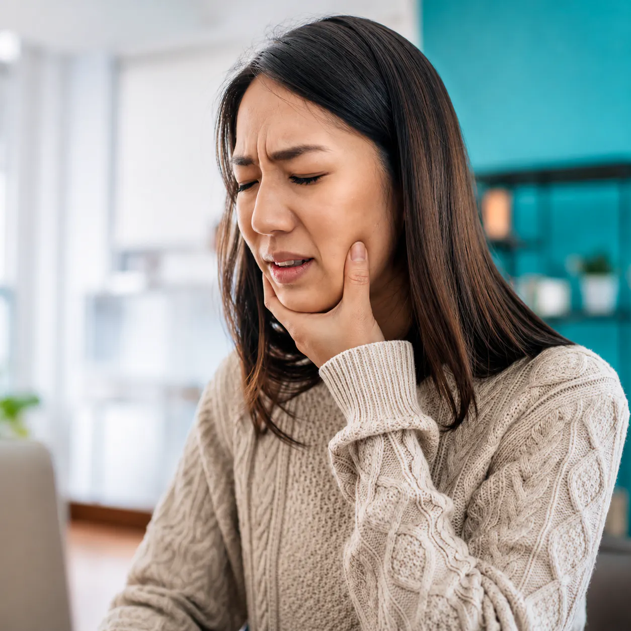 Woman holding her jaw with TMJ pain and discomfort