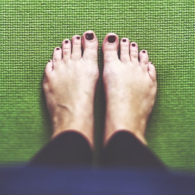 Bare feet on the green Yoga mat