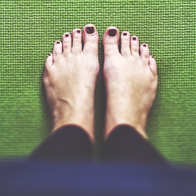 Bare feet on the green Yoga mat