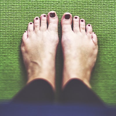 Bare feet on the green Yoga mat