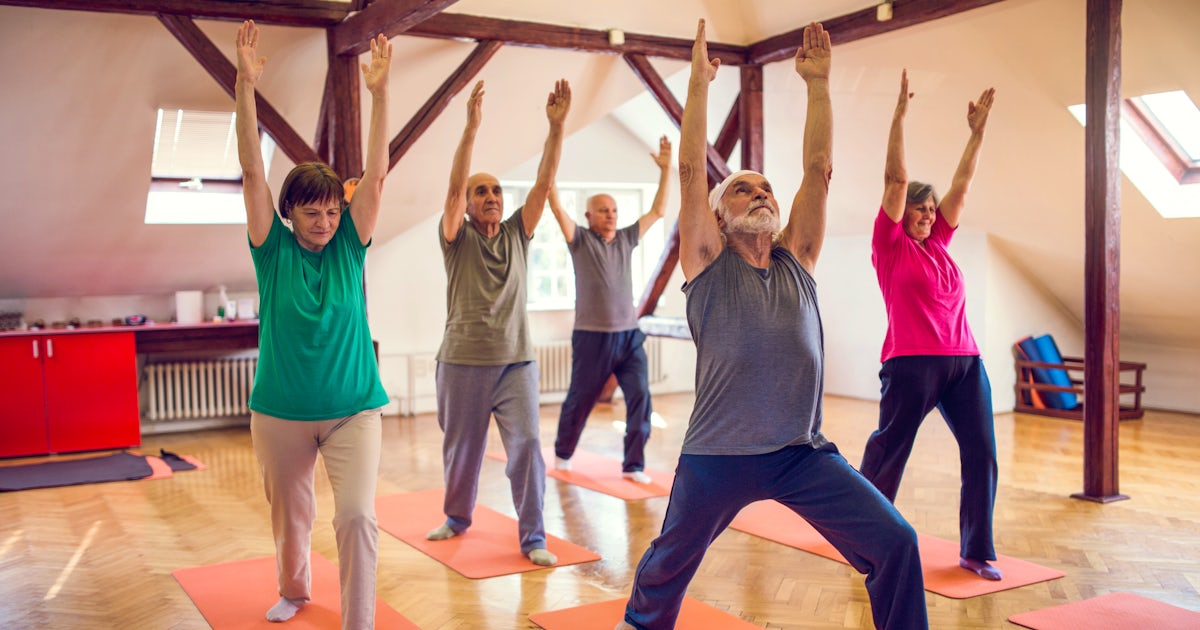 Group of old people doing stretching exercises wit