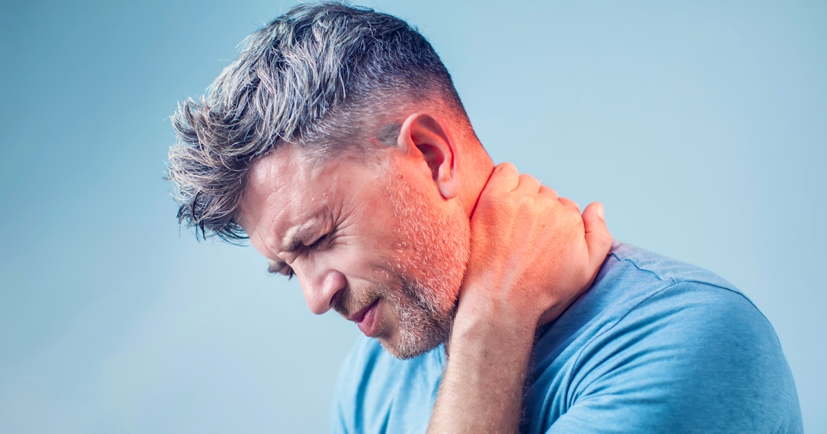 up close left side view of mans face in pain holding left arm to back of neck pain