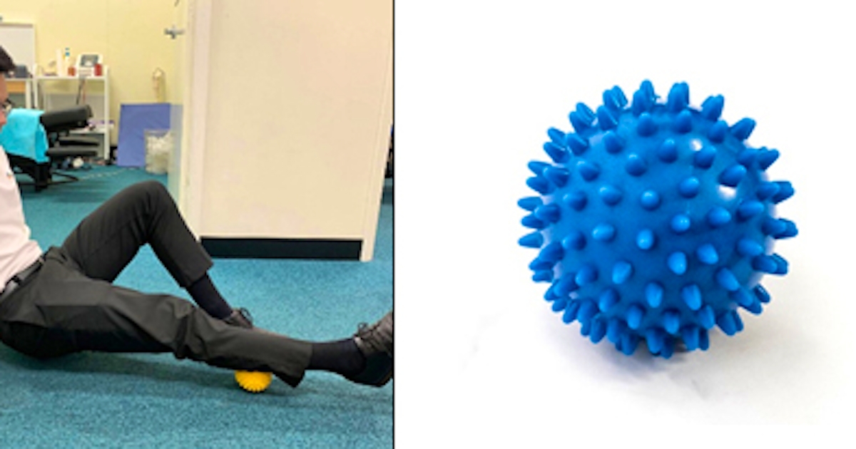 man exercising with spiky blue ball