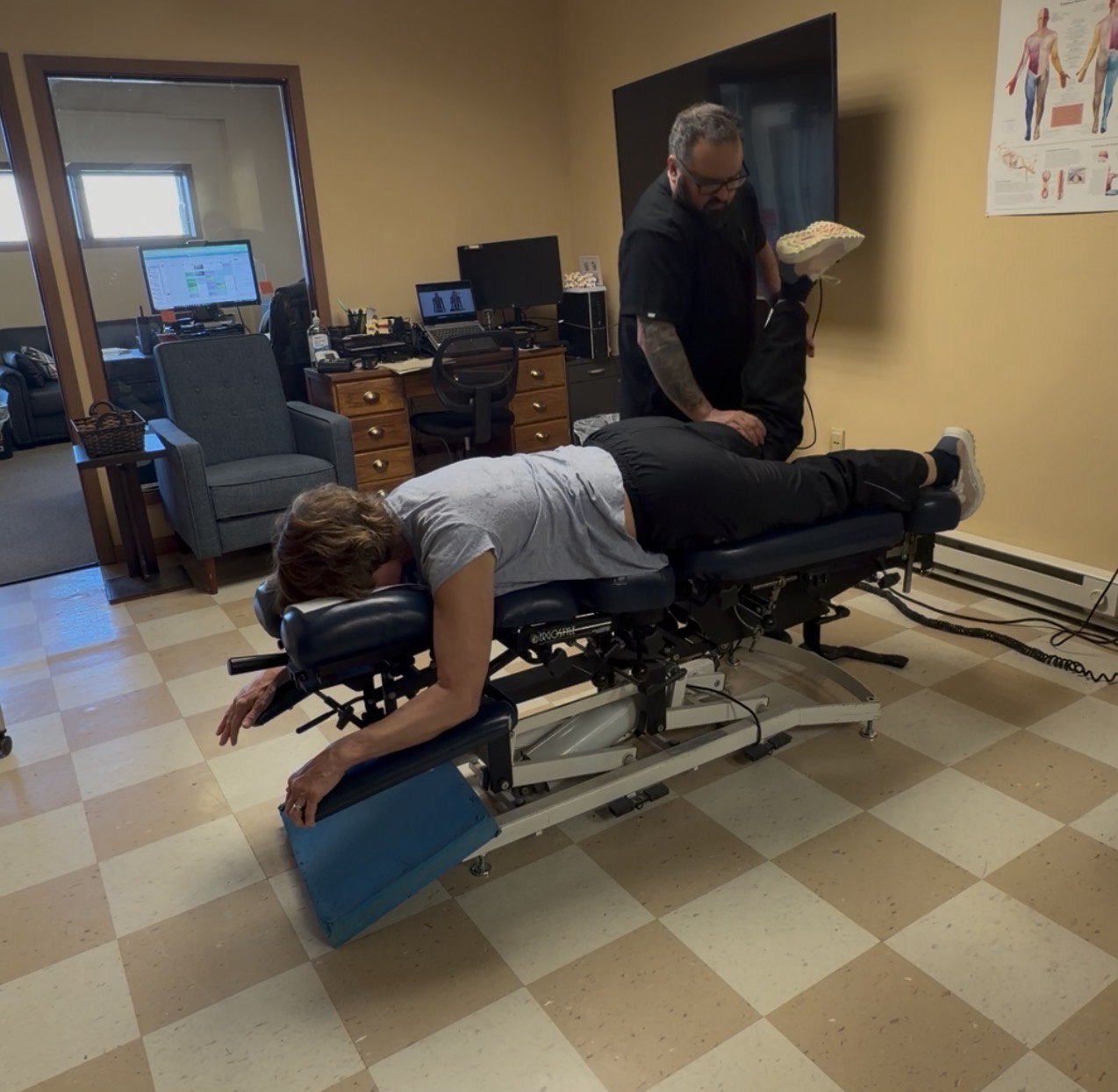 Patient receiving lower-body movement care on a chiropractic treatment table