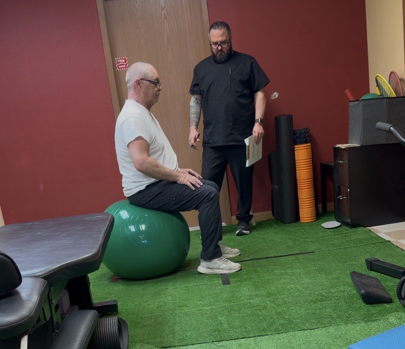 Older adult completing a seated rehabilitation exercise with a clinician