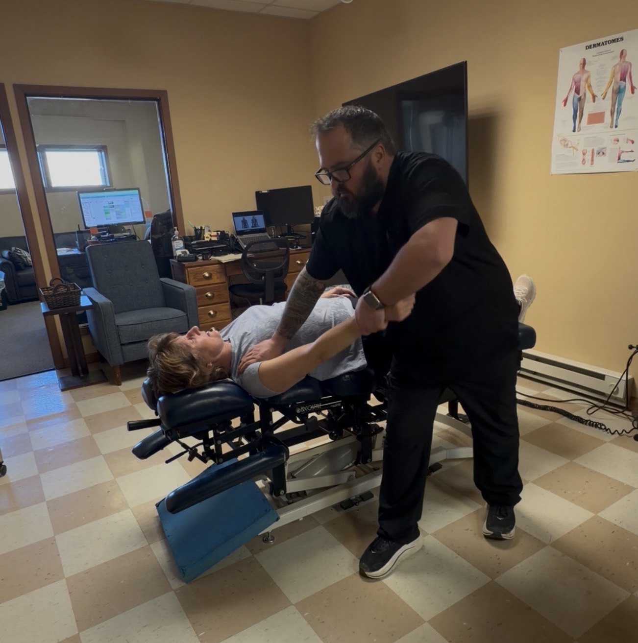 Hands-on shoulder and arm treatment being provided on a chiropractic treatment table