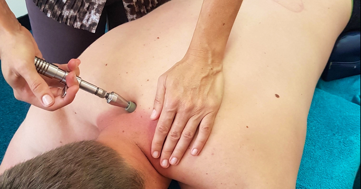 chiropractic adjustment tool on patient back