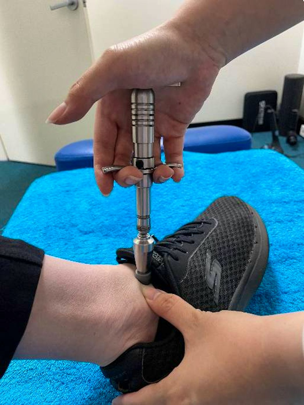chiropractic adjustment tool on patient foot