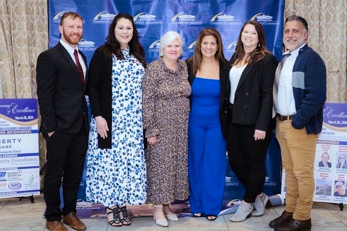 award winning woman in a group photo with 5 other people