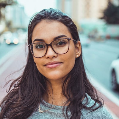 A young woman with glasses smiles