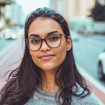 A young woman with glasses smiles