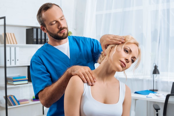 portrait-of-chiropractor-stretching-neck-of-woman